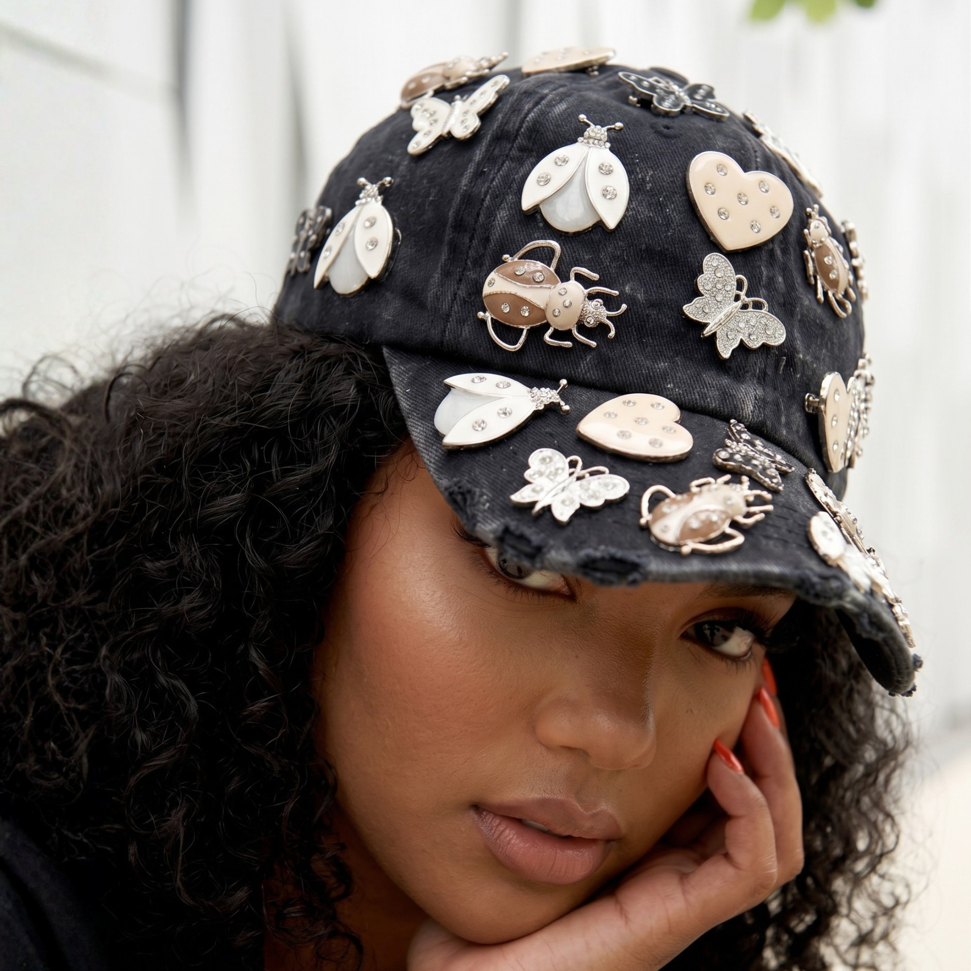 Black distressed denim ballcap featuring removable butterfly, ladybug, heart, and floral crystal brooch pins by Sassy Jones.