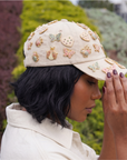 Tan distressed denim ballcap featuring removable butterfly, ladybug, heart, and floral crystal brooch pins by Sassy Jones.