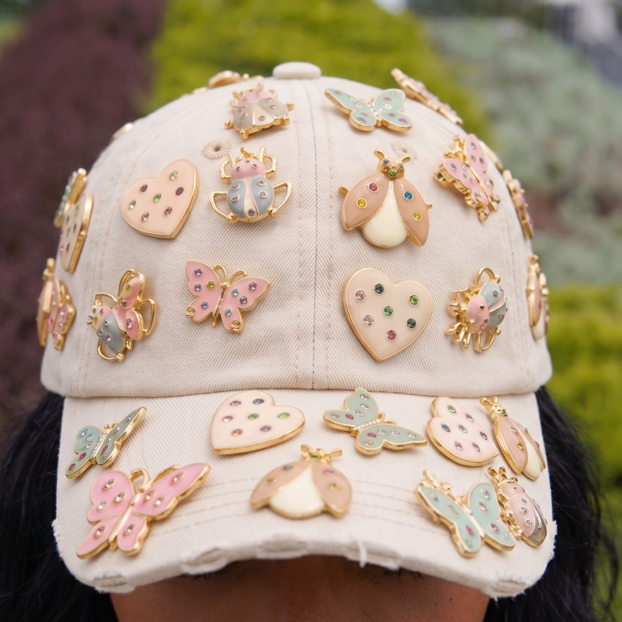 Tan distressed denim ballcap featuring removable butterfly, ladybug, heart, and floral crystal brooch pins by Sassy Jones.