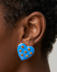Close up of Lovebug 18K Paradise Blue Stud featuring a glossy sky blue surface and sparkling amber gold crystals.