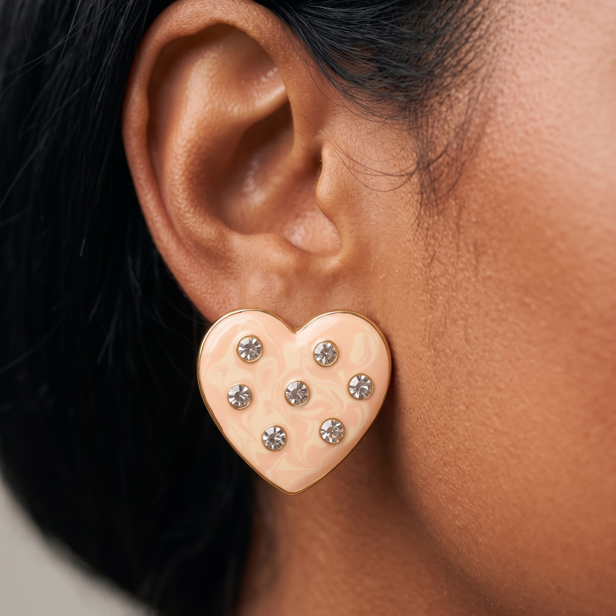 Close up of Lovebug 18K Stud showing a dimensional cream heart with seven sparkling crystal accents.
