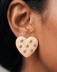 Close up of Lovebug 18K Stud showing a dimensional cream heart with seven sparkling crystal accents.