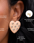 Cream heart statement earrings featuring soft swirled detailing, clear round crystals and an 18K gold plated border.