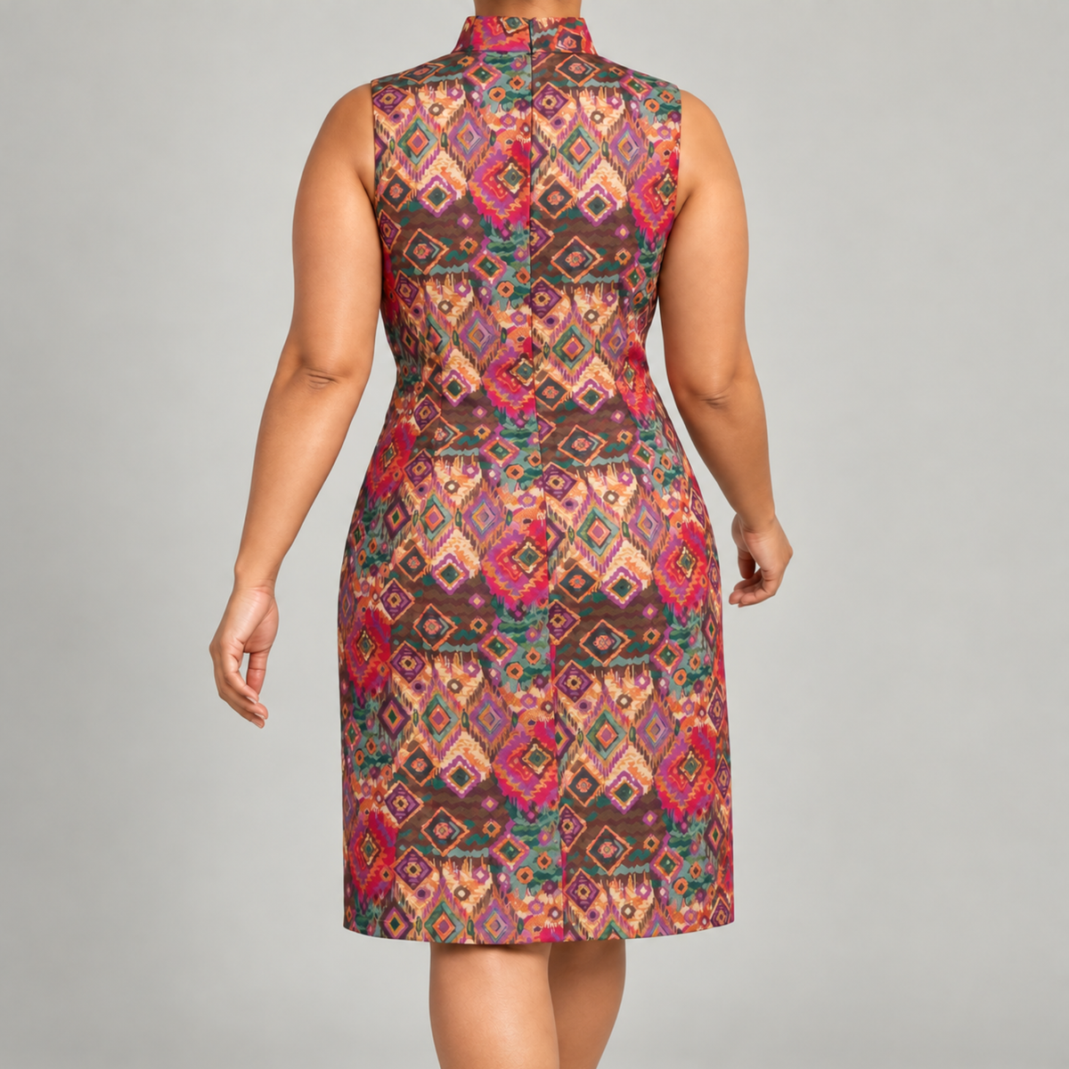 Woman wearing the Sassy Jones Margaux Shift Dress with a colorful pink, green, orange and gold geometric pattern.
