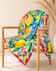 Close up of Mykonos Floral Tapestry Scarf showcasing vibrant lemons, blue and white decorative pottery and multicolor flowers.