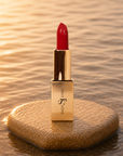 Bold red lipstick in gold tube with vibrant red swatch for a powerful statement lip look.