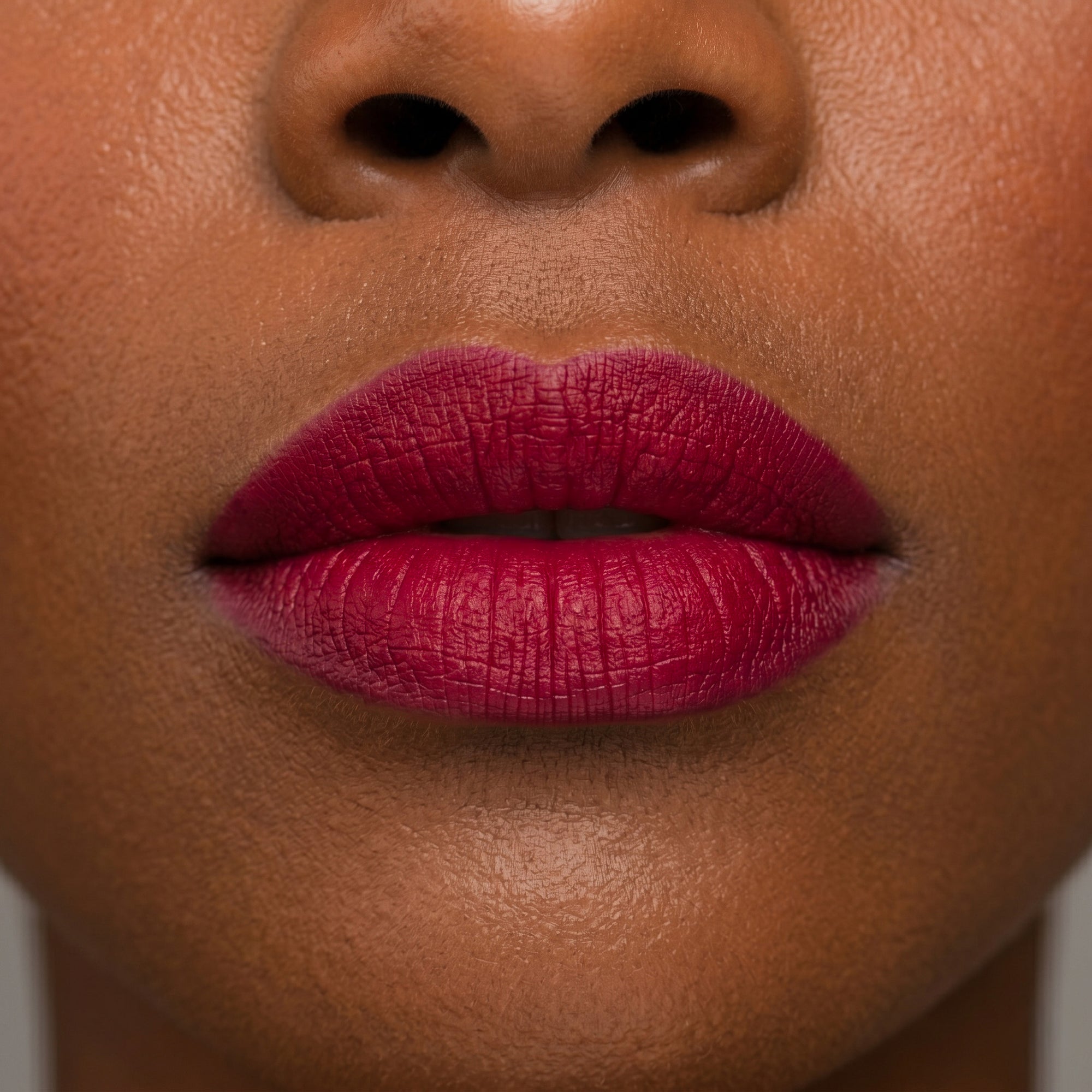 Bold red lipstick in gold tube with vibrant red swatch for a powerful statement lip look.