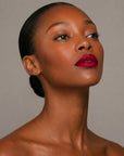 Bold red lipstick in gold tube with vibrant red swatch for a powerful statement lip look.