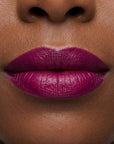 Bold violet lipstick in gold tube with vibrant purple swatch for a high impact statement lip.
