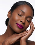 Bold violet lipstick in gold tube with vibrant purple swatch for a high impact statement lip.