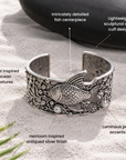 Silver statement cuff bracelet featuring a dimensional angelfish surrounded by coral inspired metalwork and pearls.