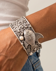 Adjustable silver cuff bracelet with central angelfish motif, dimensional bubbles and luminous pearl accents.