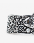 Close up of Paloma Silver Cuff featuring detailed ocean inspired metalwork, textured fish and pearl embellishments. Sculptural ocean inspired statement bracelet featuring an angelfish, coral textures and dimensional silver detailing.