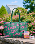 Pretty In The City promotional bundle featuring the Pink & Green Sassy City Tote, Maverick Lip Liner, Off Black Sculpt & Serve Brow Pencil, Confidence Card Stack, and Roxie Radiance Cuff by Sassy Jones.