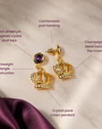 Reign dangle earrings with deep purple round studs and ornate 18K gold plated crown pendants.