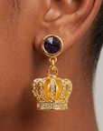 Close-up of Reign crown earring featuring purple gemstone-style stud and sparkling pavé details.