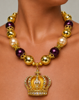 Close-up of ornate pavé crown pendant with champagne center and Gold tone finish.