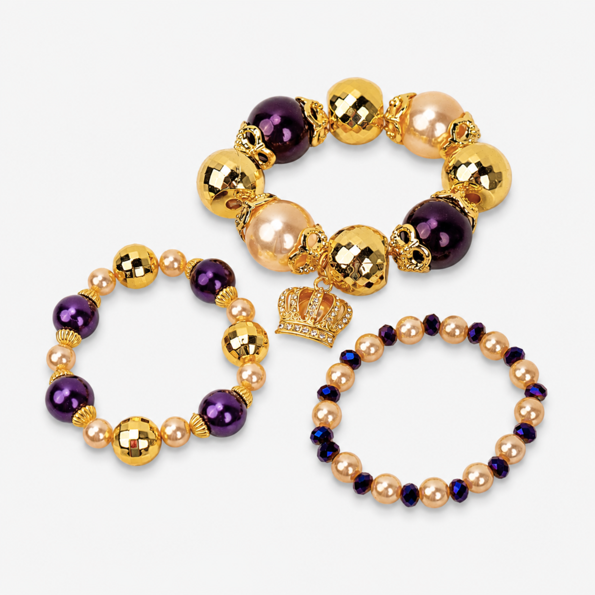 Three-piece Reign bracelet stack featuring champagne pearls, deep purple beads and gold accents.