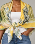 Sassy Jones Samba Serengeti Scarf showcasing an illustrated elephant, giraffe, zebra, rhinoceros and lions in a savanna setting.