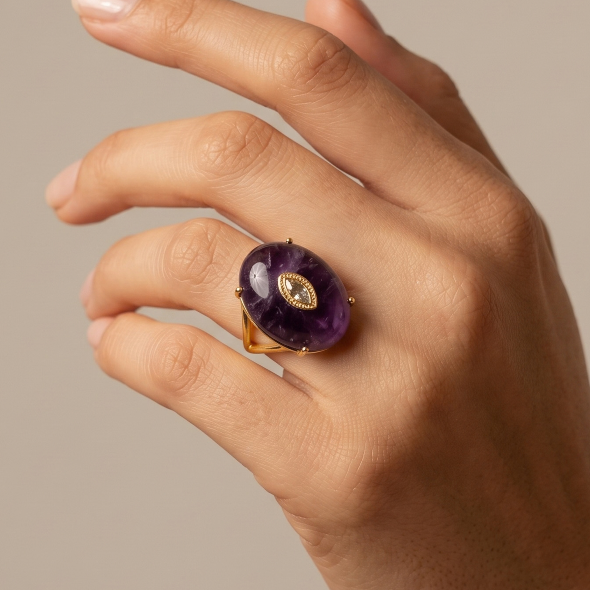 Purple statement ring featuring a polished stone, light contrasting centerpiece and Gold tone finish.