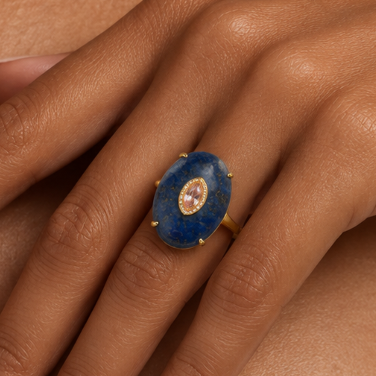 Navy statement ring featuring a smooth blue stone, petite lavender detail and Gold tone finish.