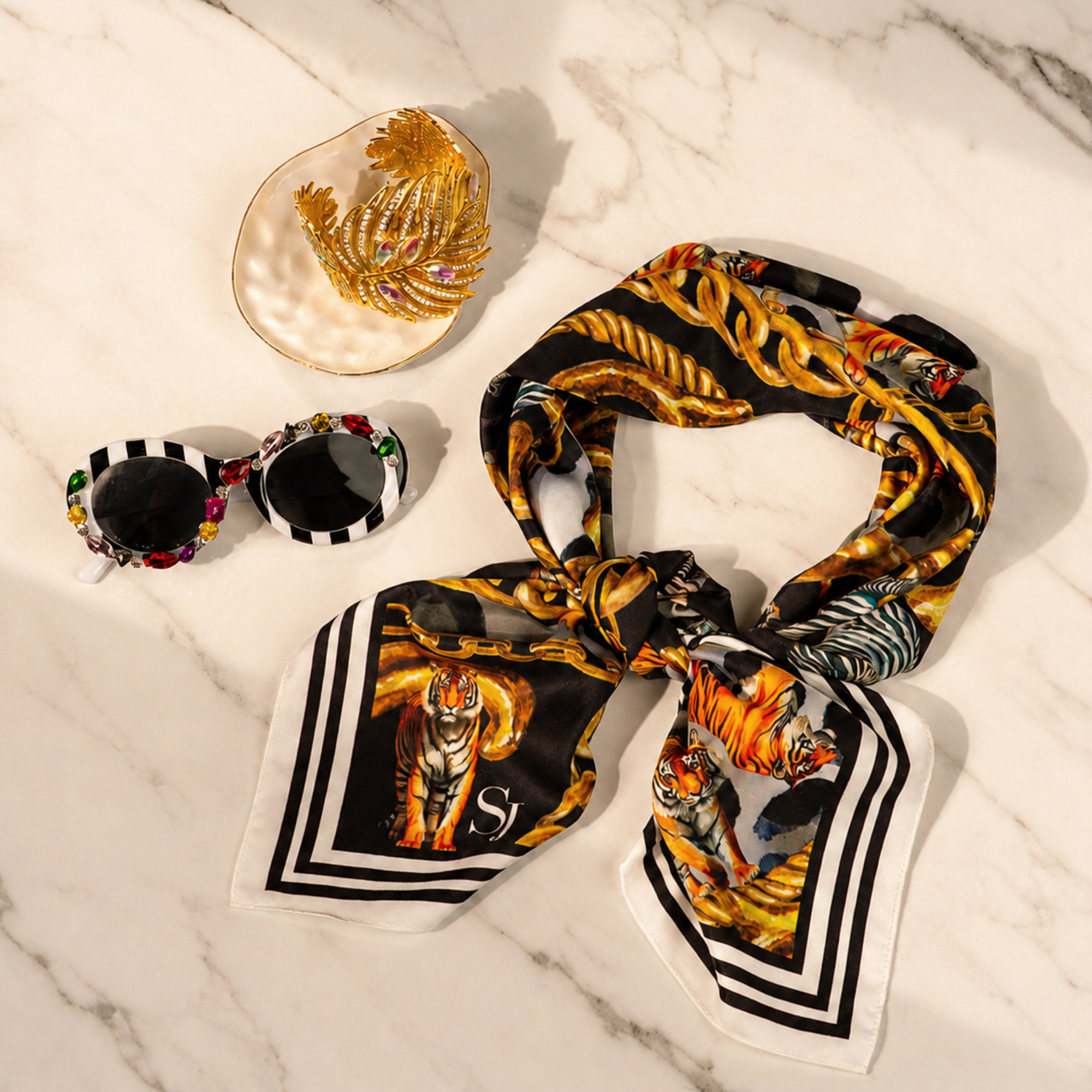 Complimentary Sassy Chic Trio featuring striped gemstone sunglasses, gold palm cuff and black printed square scarf.