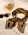 Complimentary Sassy Chic Trio featuring striped gemstone sunglasses, gold palm cuff and black printed square scarf.