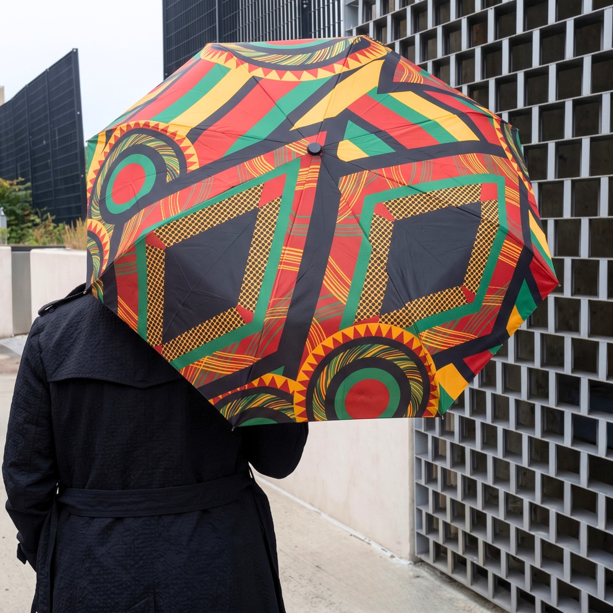 Complimentary Afrikaan folding umbrella with colorful African inspired artwork and bold circular motifs.