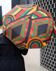 Complimentary Afrikaan folding umbrella with colorful African inspired artwork and bold circular motifs.