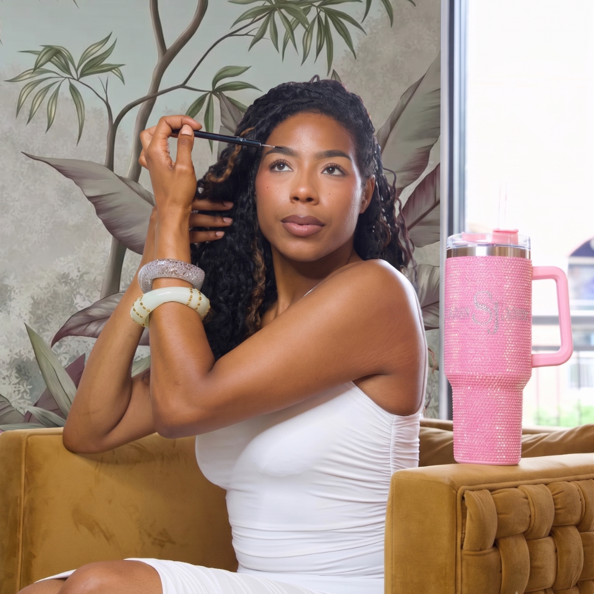 Sip, Sparkle &amp; Slay Set featuring a pink crystal sparkle tumbler, light brown brow pencil, Noemi Mirage shimmering bangle, and Jumanji Untamed Beauty ivory statement bangle.