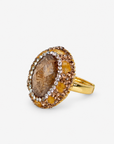 Amber statement ring featuring a textured brown centerpiece with layered crystal and Gold tone finish detailing.