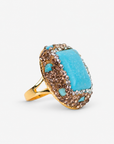 Teal statement ring featuring a veined blue green centerpiece with textured Gold tone finish detailing.