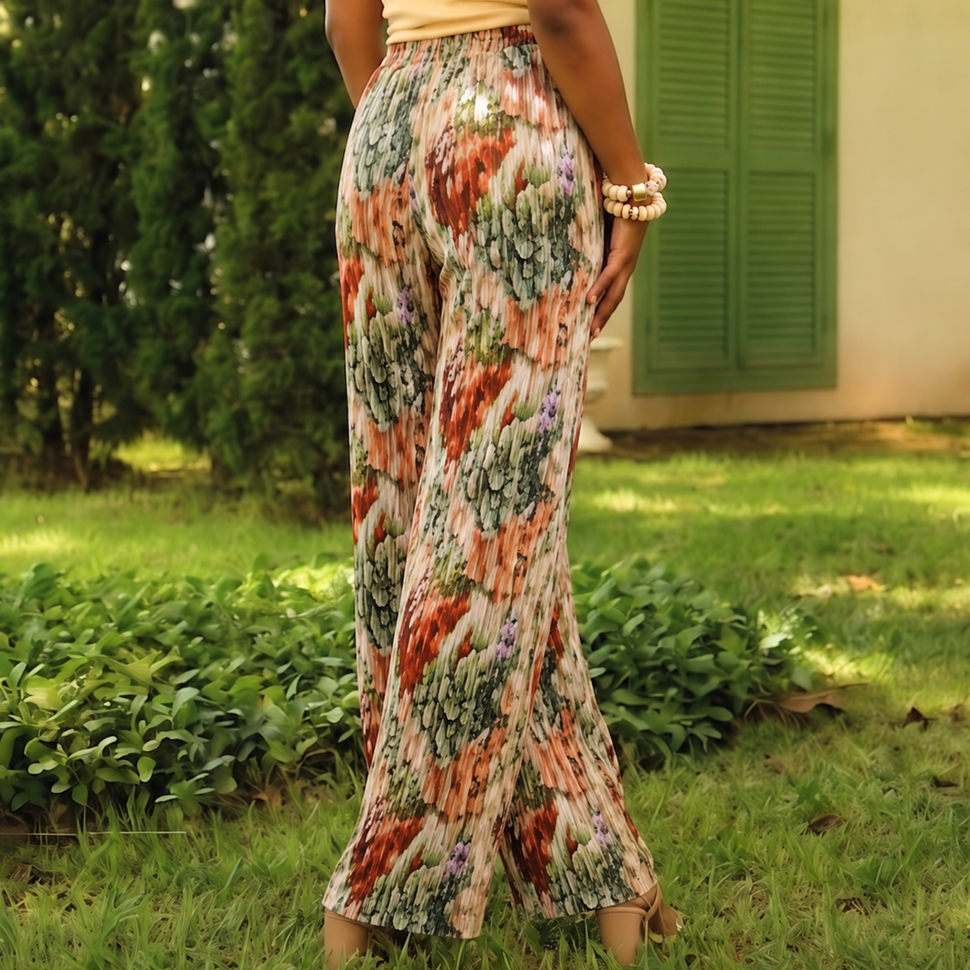 Women's silky pleated wide leg floral pants featuring a watercolor botanical print in sage, terracotta, blush, and cream with a comfortable pull on waistband.
