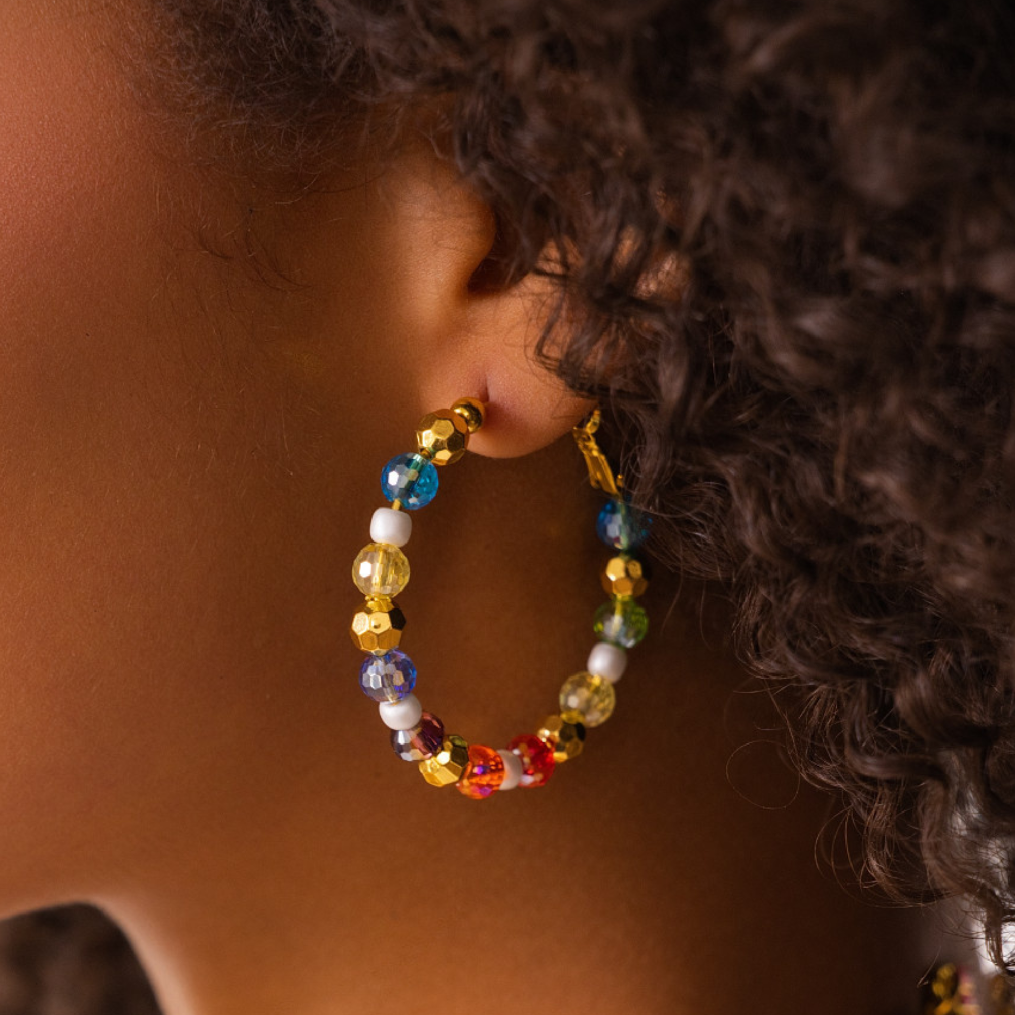Colorful glass bead and pearl hoop earrings with gold accents designed for playful luxury styling