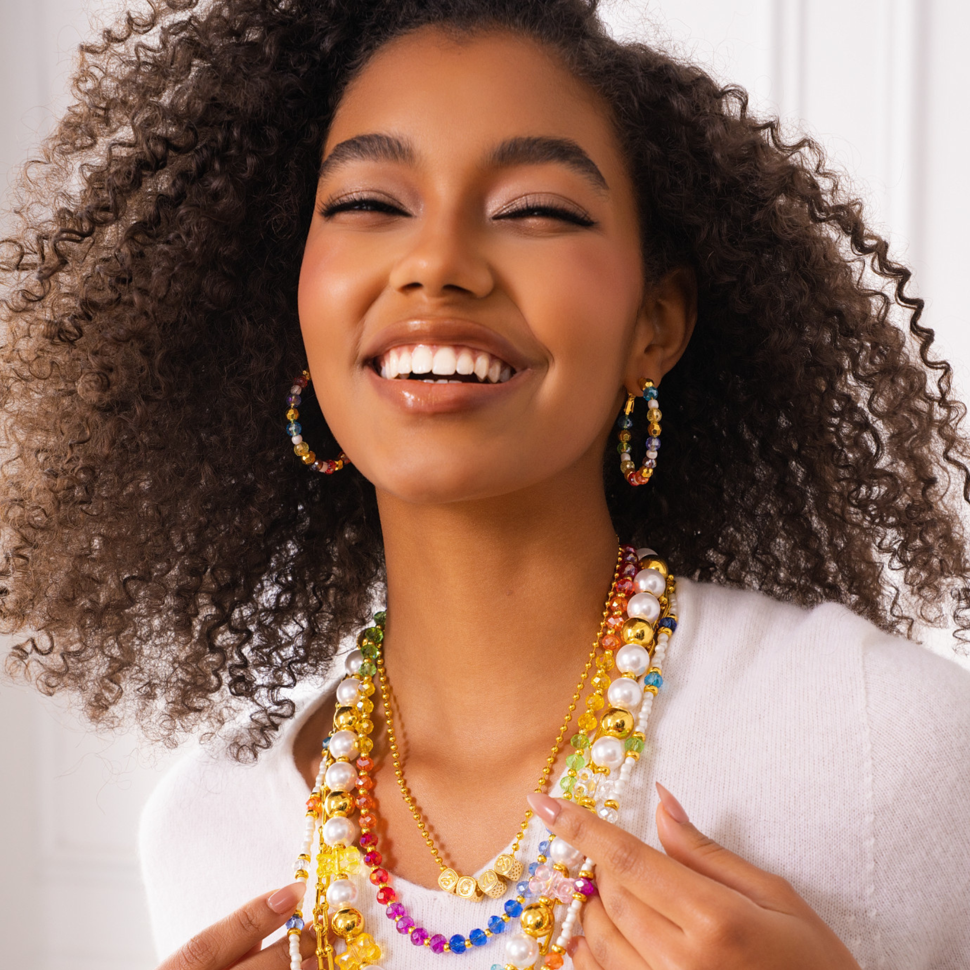 Colorful glass bead and pearl hoop earrings with gold accents designed for playful luxury styling