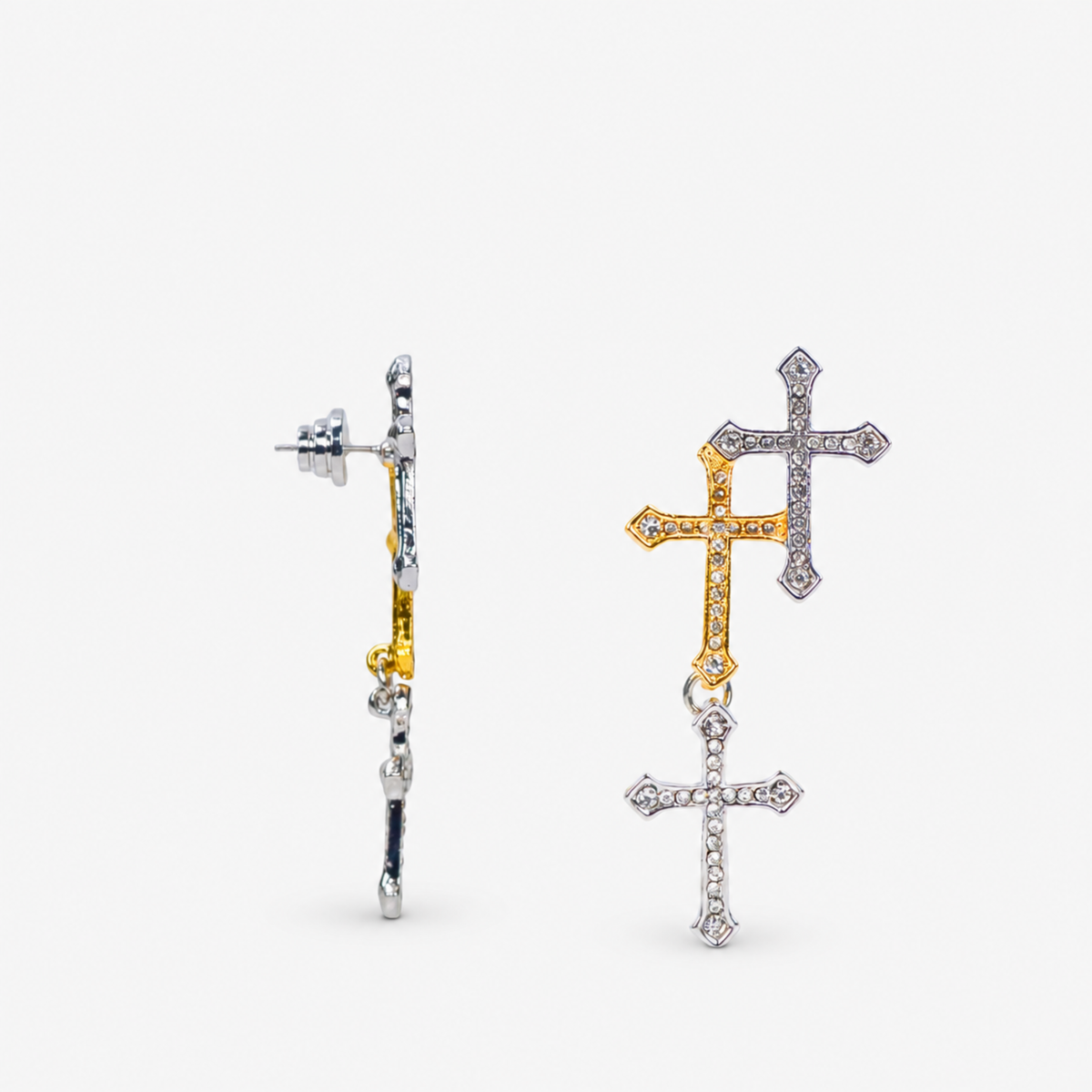 Trinity 18K Cross Sparkling Earrings featuring three cascading crystal crosses in gold and silver finishes.   Woman wearing Trinity statement earrings with layered gold and silver crystal cross motifs.   Sassy Jones Trinity drop earrings featuring three sparkling crosses in contrasting mixed metal finishes.   Close up of crystal cross earrings with a silver cross stud, gold center cross and dangling silver cross.   Trinity faith inspired earrings featuring cascading crystal embellished crosses in gold and s