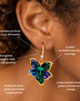 Sassy Jones Valerie floral dangle earrings featuring faceted green center stones and colorful crystal petals.