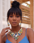Statement peacock earrings featuring hand painted enamel feathers, sparkling crystal accents, gold shell studs, and colorful jewel toned detailing.