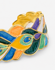 Sculptural peacock inspired cuff bracelet with colorful hand painted enamel style detailing and Gold tone finish.