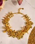 18k gold sculptural floral statement necklace with layered petals and reflective discs inspired by cascading wisteria blossoms worn on a woman's neckline