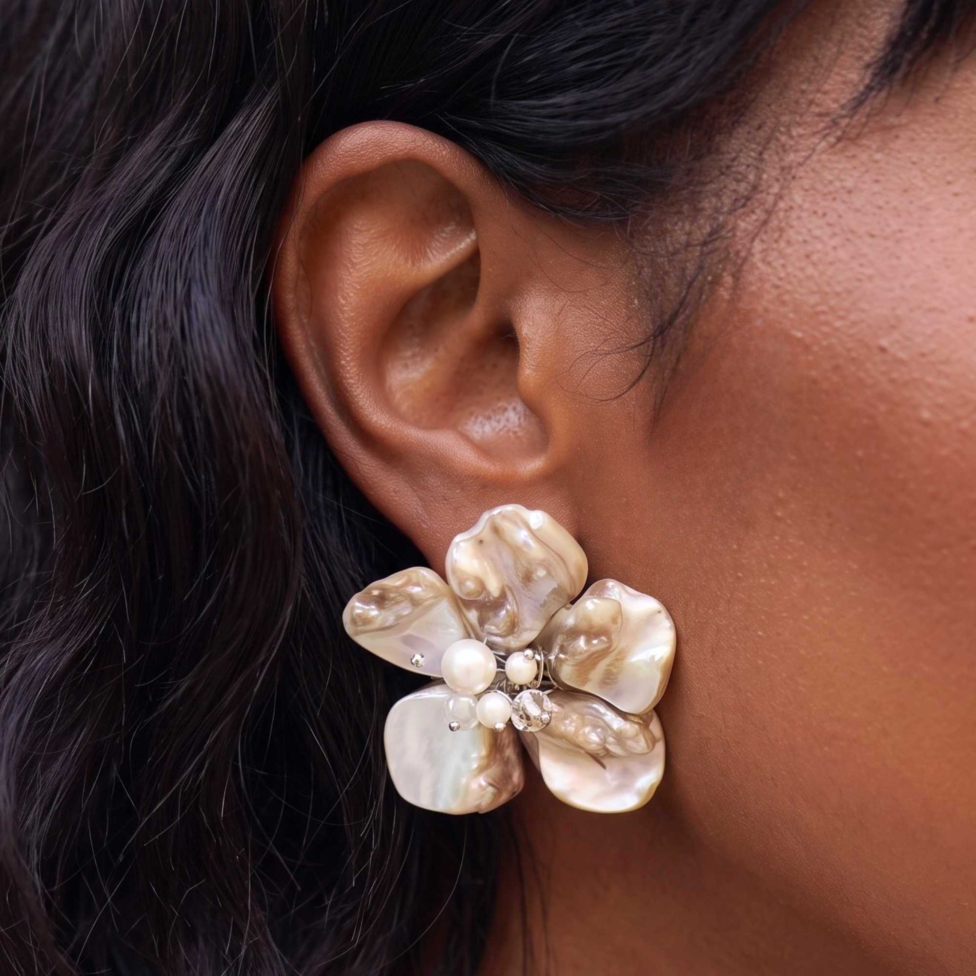 Statement floral earrings handcrafted from Mother of Pearl petals with freshwater pearl accents and sculptural botanical detailing.