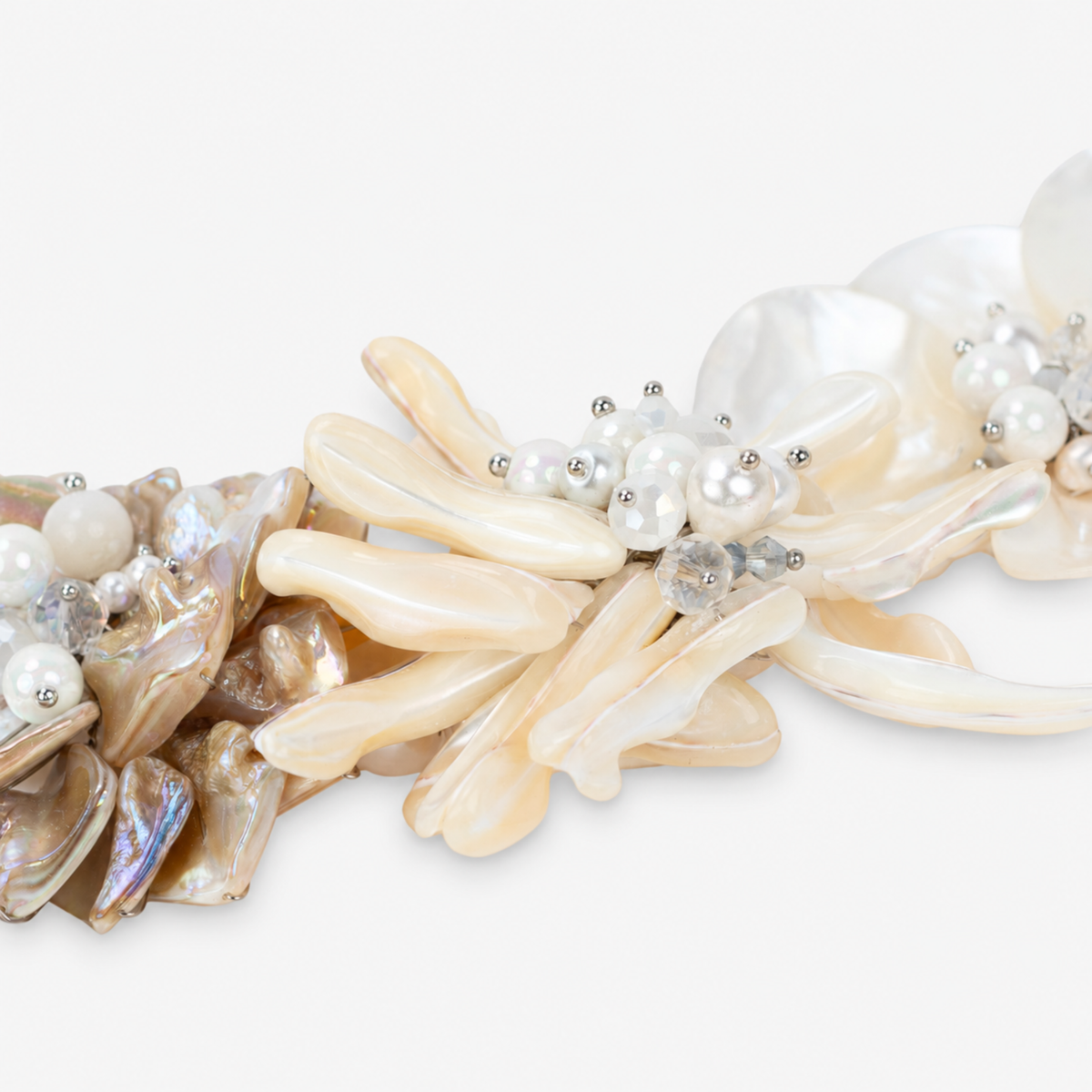 Mother of pearl floral statement necklace with sculptural petals and pearl clusters inspired by wisteria blossoms worn on a woman's neckline