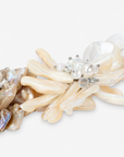 Mother of pearl floral statement necklace with sculptural petals and pearl clusters inspired by wisteria blossoms worn on a woman's neckline