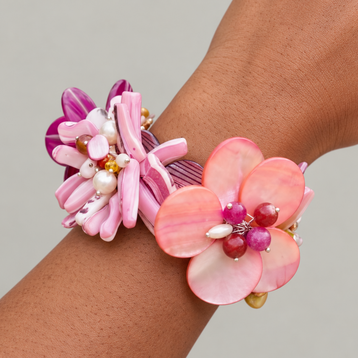 Wisteria Pink and Orange Abalone Bracelet featuring sculptural flowers crafted from laser cut mollusk shell in vibrant sunset colors.