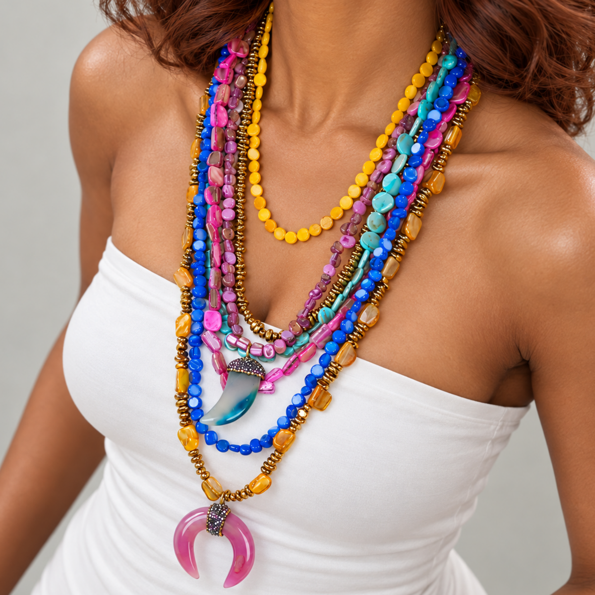 Multistrand Zuma statement necklace featuring rainbow shell beads, sparkling spear detail, and pink crescent pendant.