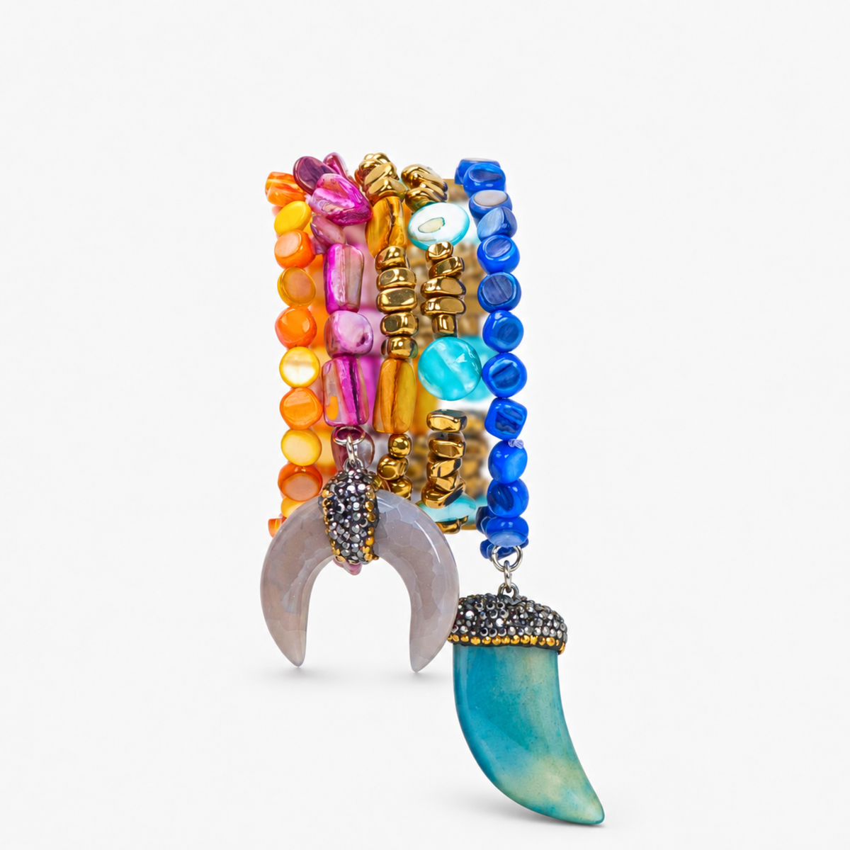 Zuma multicolor bracelet stack featuring vibrant hand strung beads and blue and natural shell pendants with sparkling accents.

Close-up of Zuma five piece bracelet stack with colorful shell beads, golden hematite, chalcedony, and sculptural dangling charms.