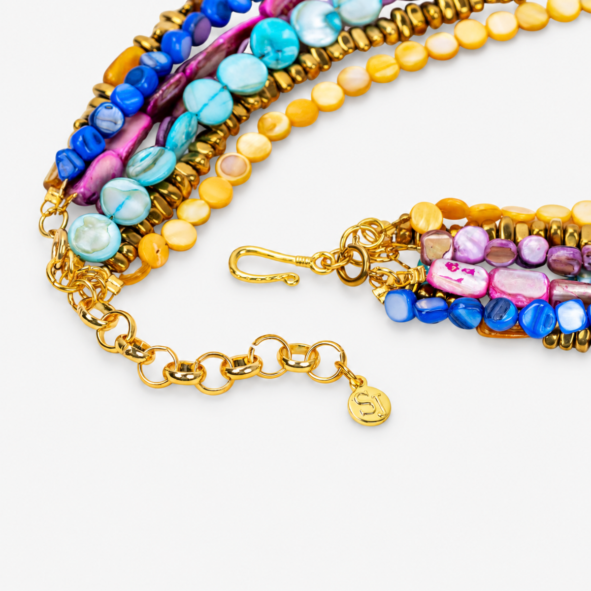 Colorful layered shell necklace featuring vibrant bead strands and a detachable pink crescent charm.
Zuma multicolor statement necklace featuring cascading shell beads, dimensional crystal detailing, and sculptural crescent pendant.