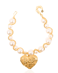 Close-up of Amora gold and pearl statement necklace on neckline.