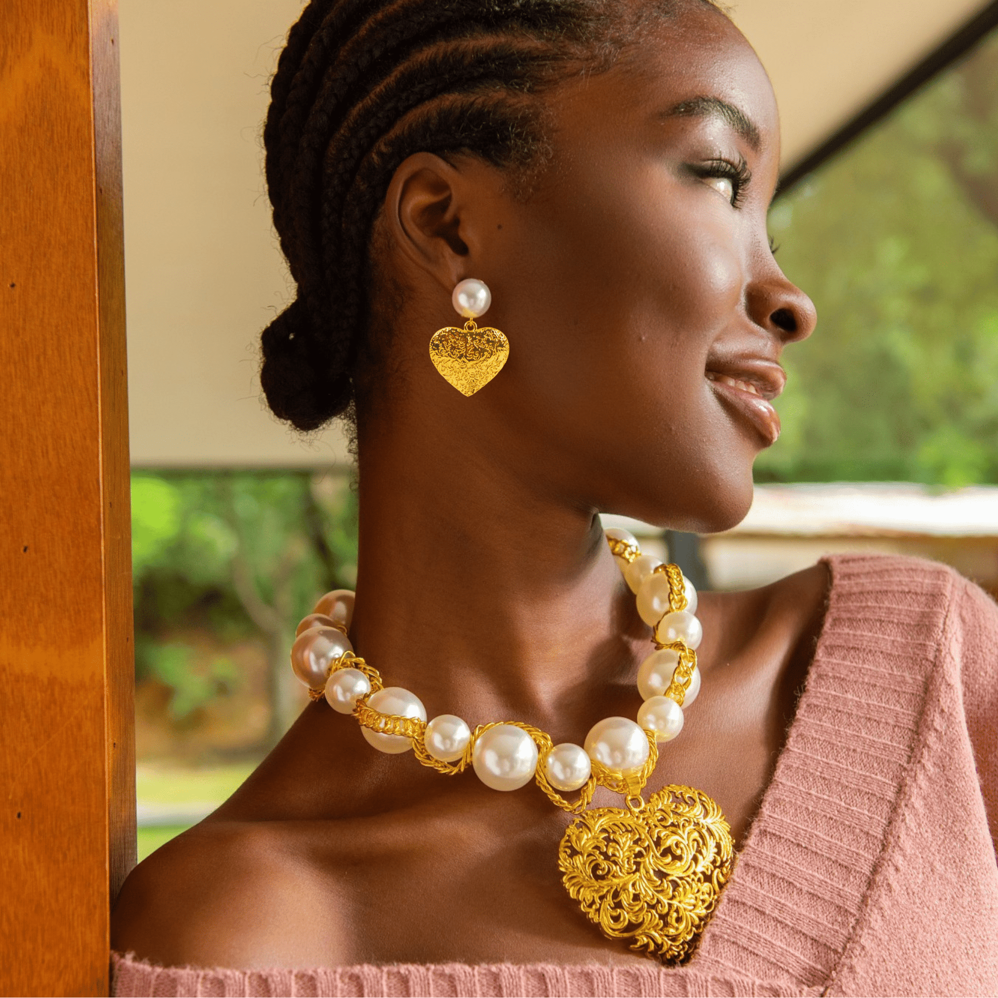 Model wearing Amora Pearl Heart Dangles with matching necklace and bracelet.