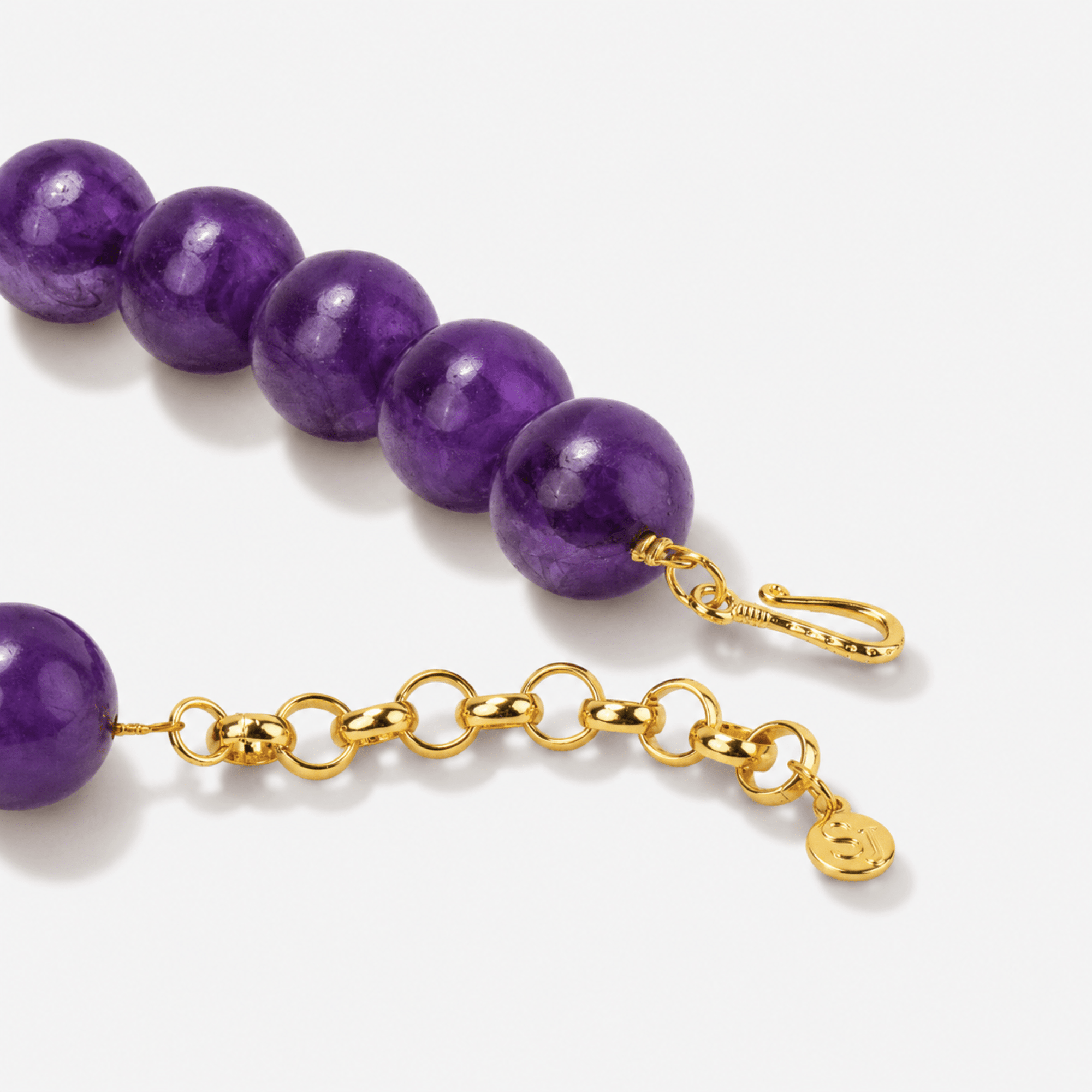 Purple beaded necklace with oversized natural agate slice pendant framed in gold.